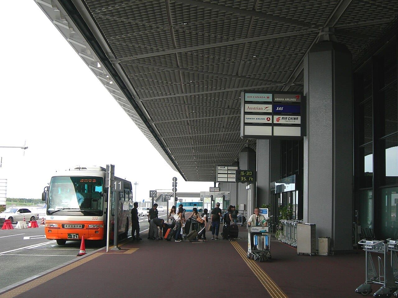 나리타공항 터미널 앞에 정차한 주황색과 흰색 공항 리무진버스